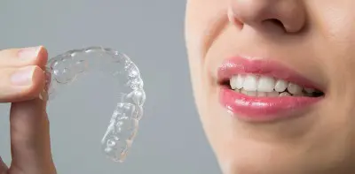 smiling woman with an Invisalign aligner