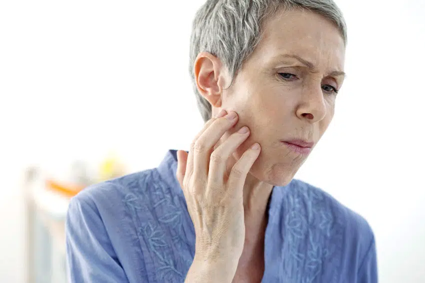 mature woman suffering from TMJ jaw pain