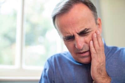 middle aged man suffering from jaw pain