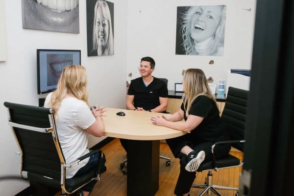 dentist, patient, and hygienist in consultation room