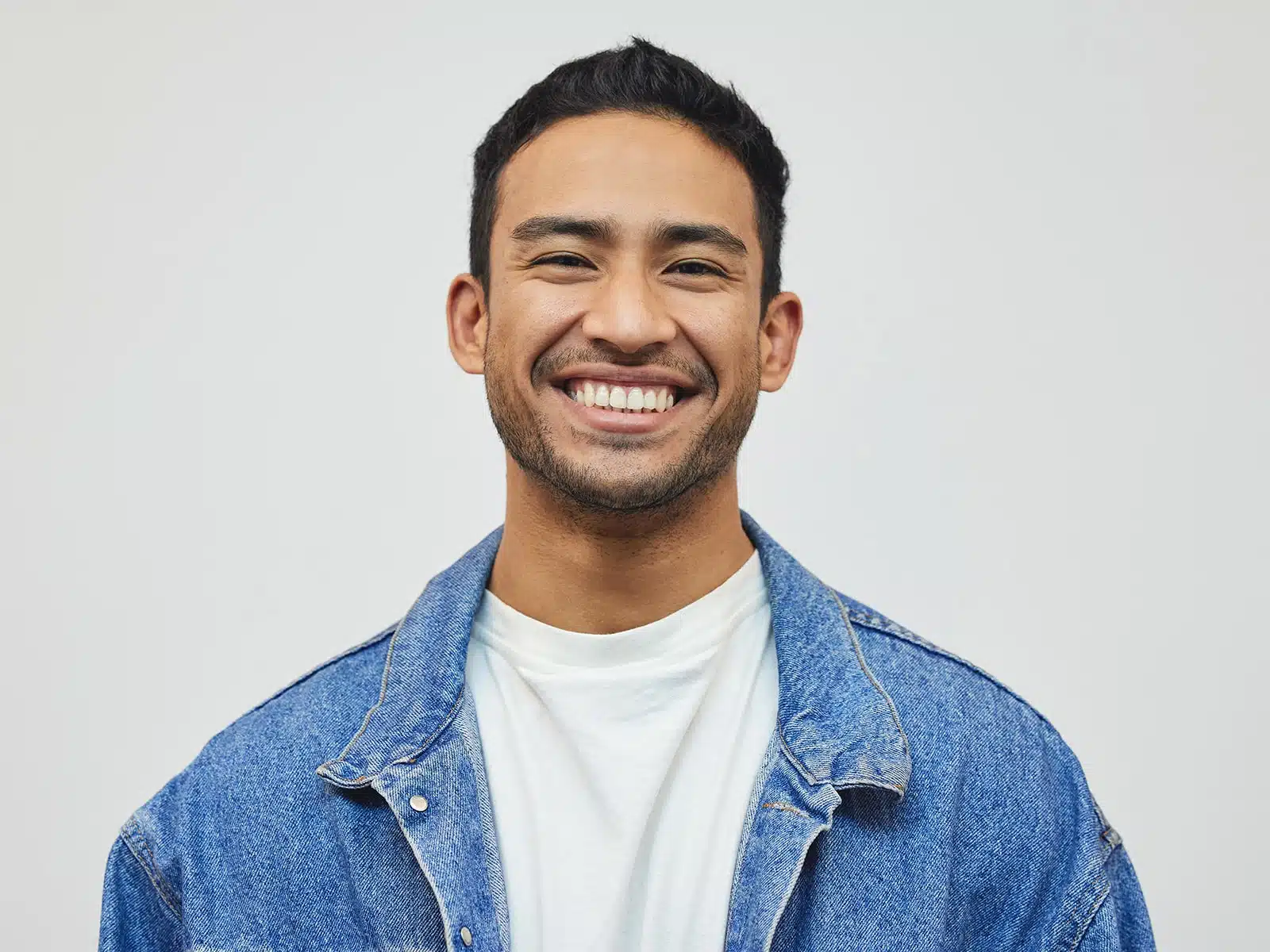 Young man smiling wearing a jean jacket