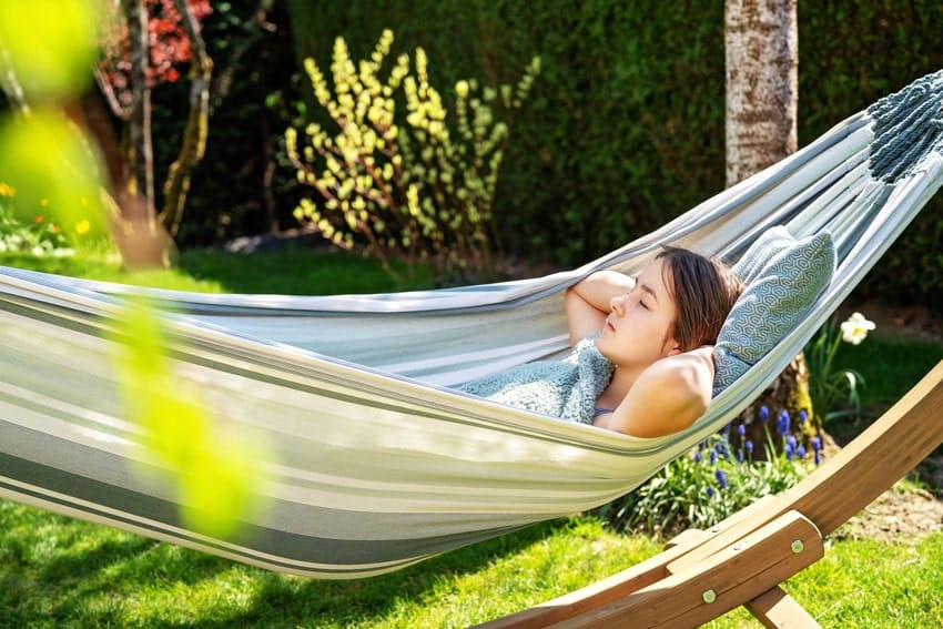 young adult woman sleeping in a hammock during the day