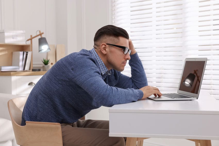 adult man sitting at his computer with poor posture